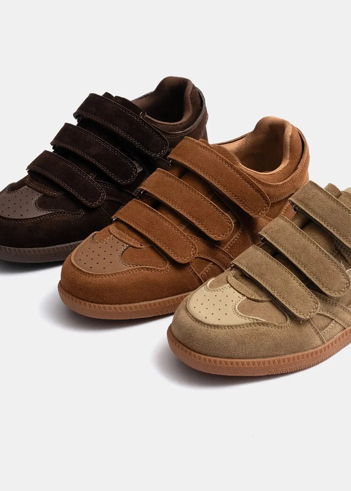 Three pairs of brown eluxeri easewalks with velcro straps on a white background