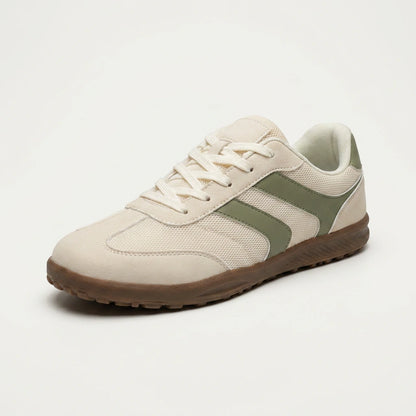 Beige sneaker with a green accent on a white background