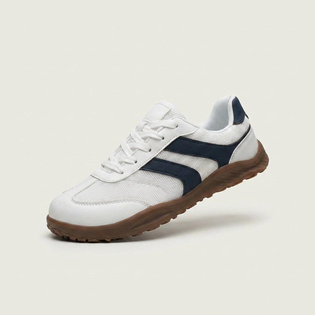 White sneaker with navy accents on a light beige background
